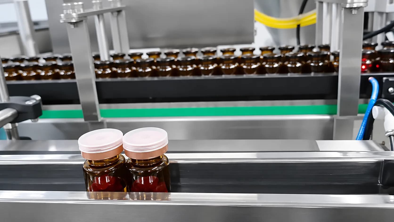 Capped amber bottles on conveyor output rails